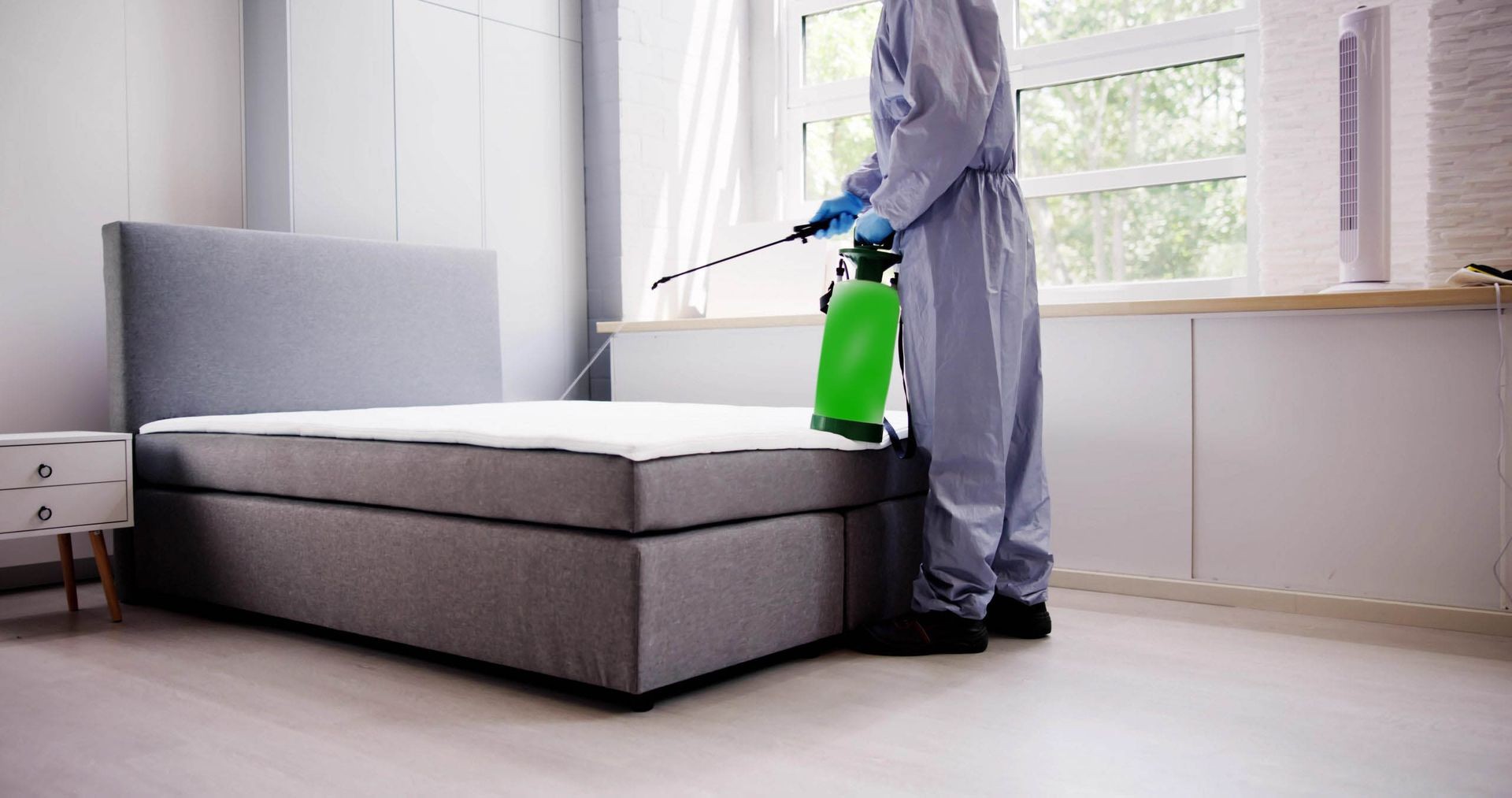 Professional technician providing Bed Bug Extermination Services by carefully inspecting a mattress for pest infestation in Toronto.