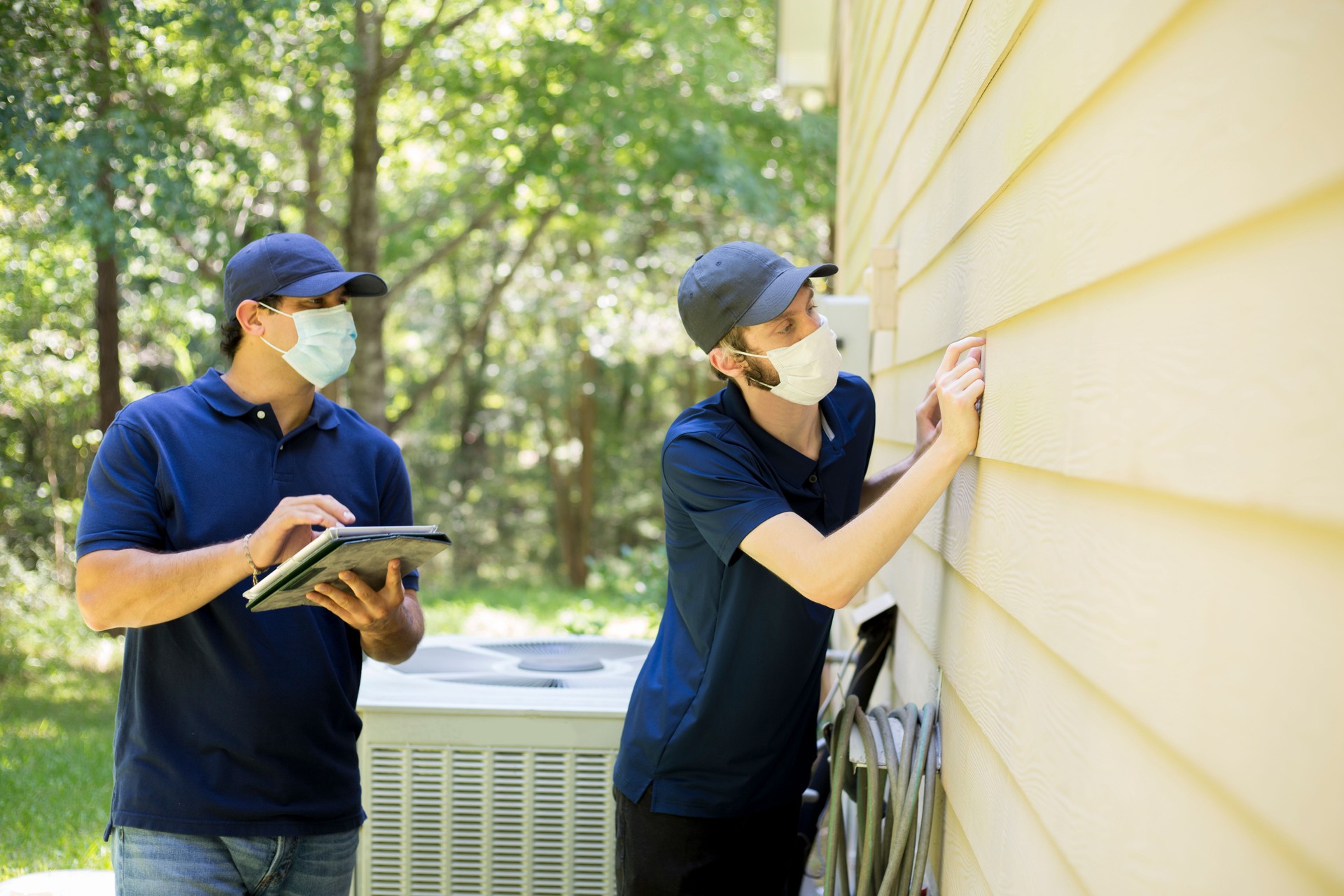 Inspector or blue collar workers examine building walls.  Outdoors.